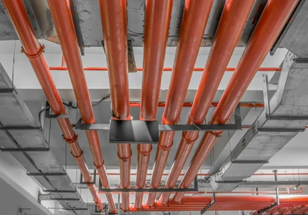 Mechanical room with commercial heating system components, including piping, valves, and equipment used for maintenance and repair services.